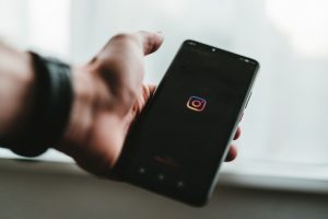 Person holding phone showing Instagram logo
