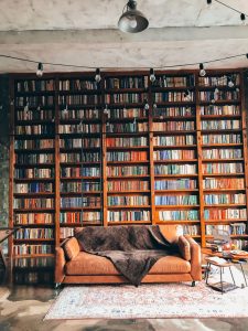 Wall to floor bookcases, with a sofa in front. Photo by Mariia Zakatiura on Unsplash